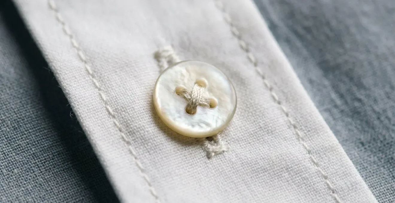 Gros plan macro sur les détails de finition d'une chemise de qualité révélant la texture du tissu et les coutures