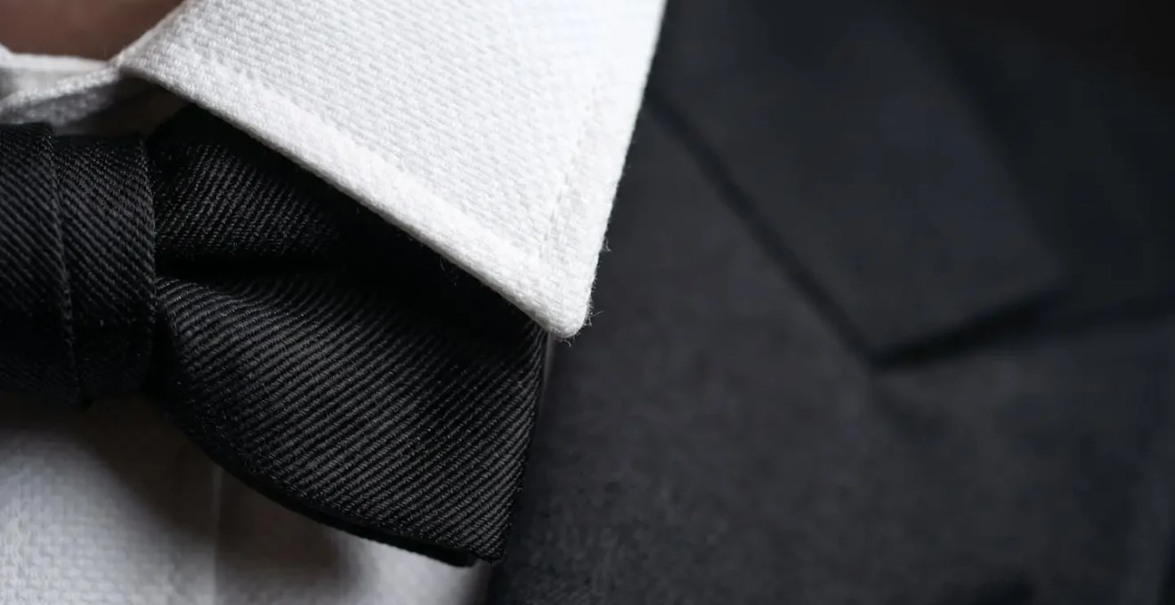 Détail macro d'un col de chemise avec nœud papillon illustrant les proportions idéales