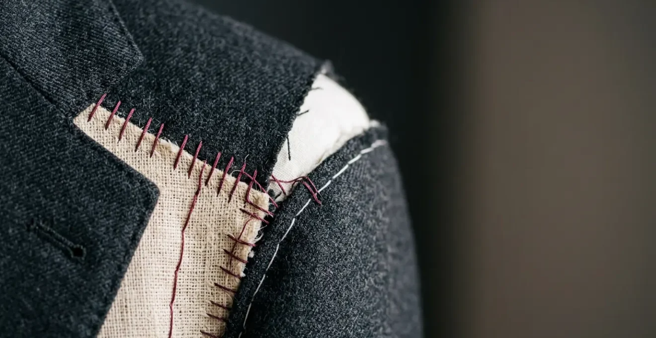 Détails de construction d'une veste de costume sur mesure masculine illustrant les points critiques d'ajustement