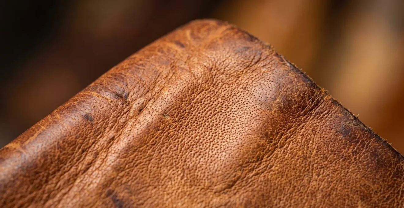 Gros plan macro sur la texture d'un cuir pleine fleur vieilli montrant sa patine naturelle